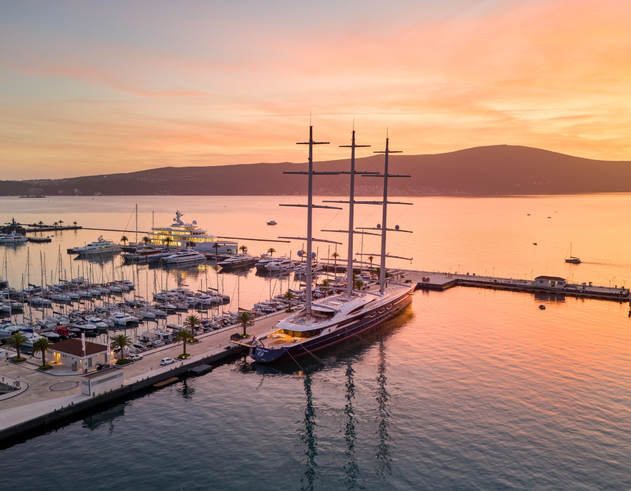 Porto Montenegro marina at sunset, showcasing a variety of yachts docked along the piers.