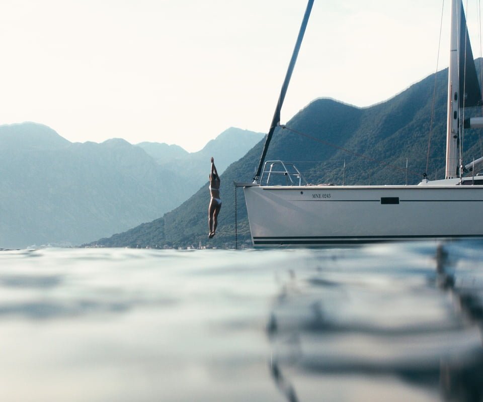 Woman jumping off yacht into water