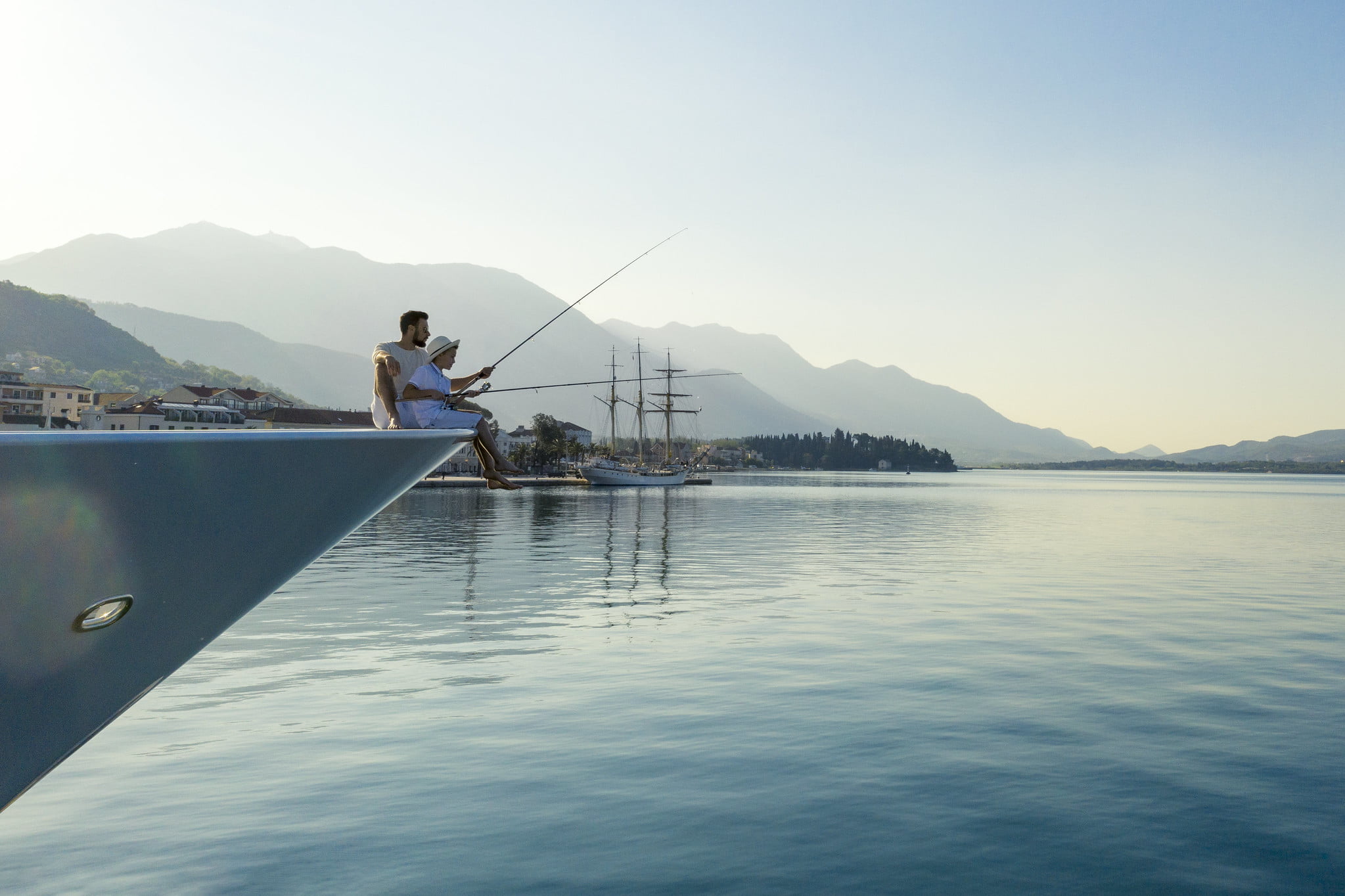Father and son fishing off yacht