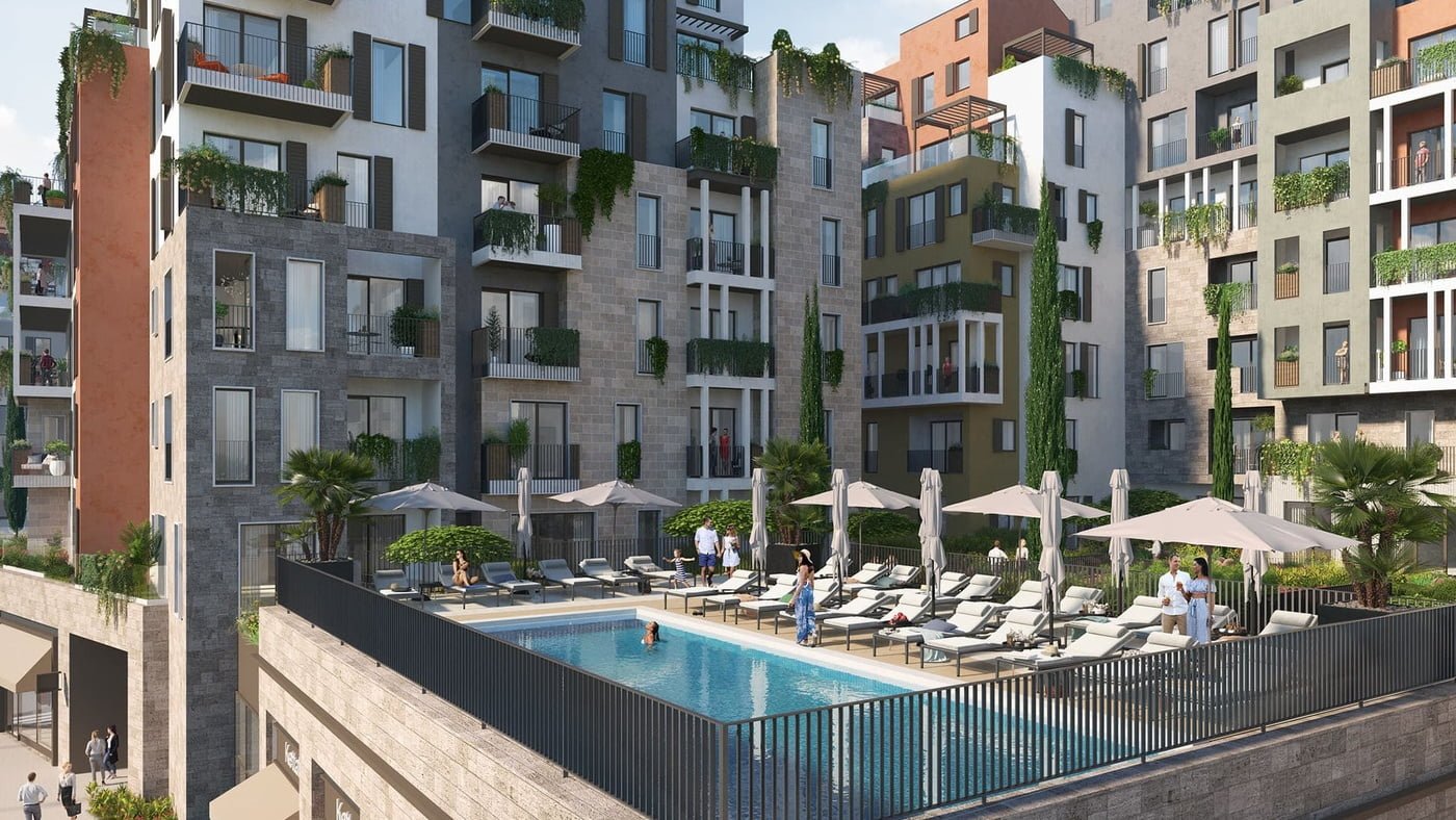 Luxury Boka Bay apartment complex with verdant balconies overlooking a communal swimming pool area.