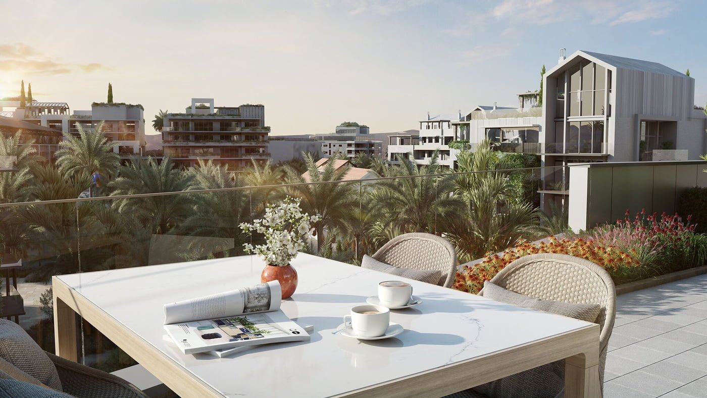 Rooftop patio with a white marble table set with coffee cups, overlooking a lush landscape of palm trees.