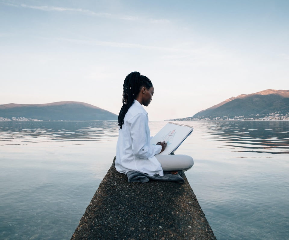Woman sketching by the ocean