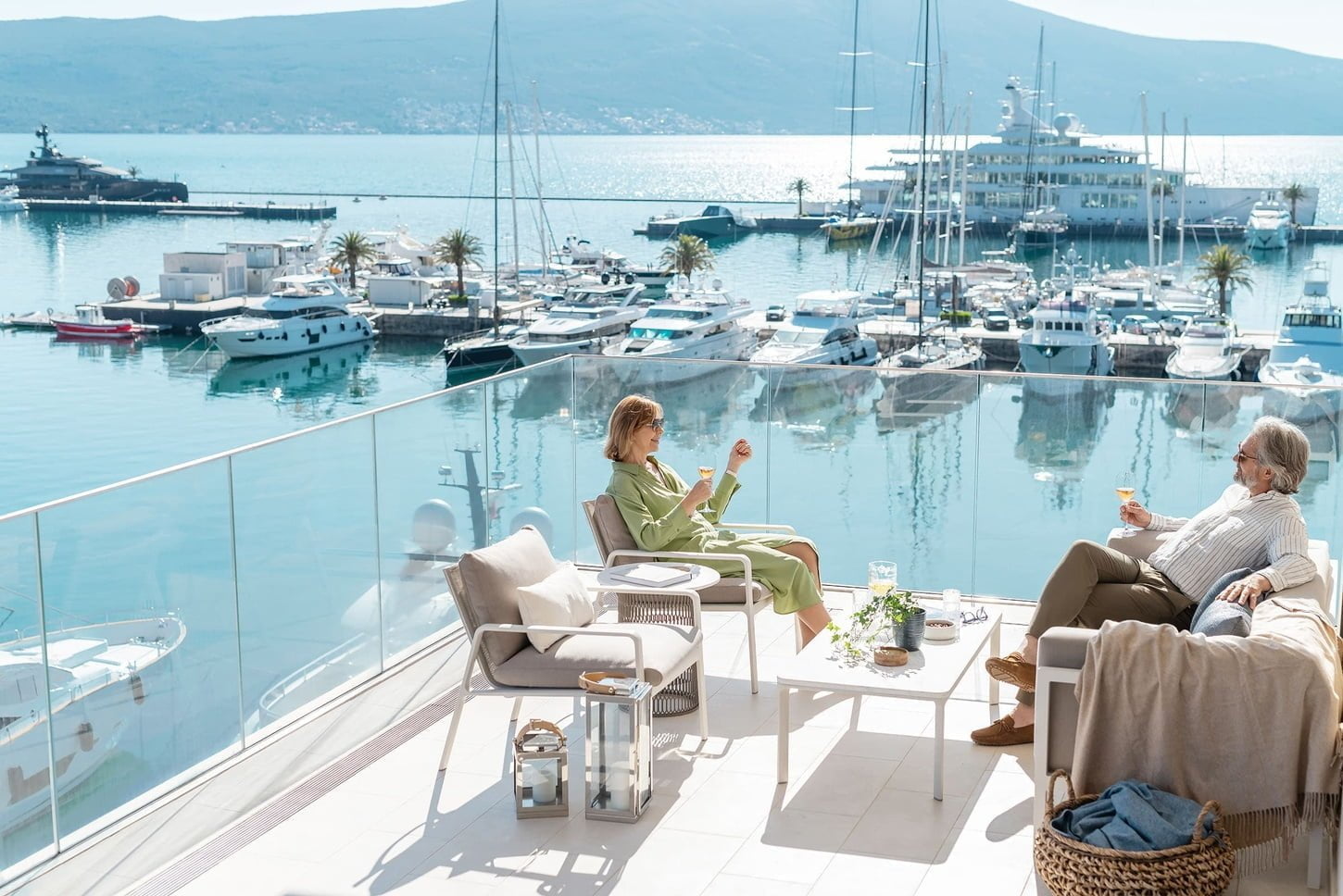 Couple sitting on balcony overlooking marina