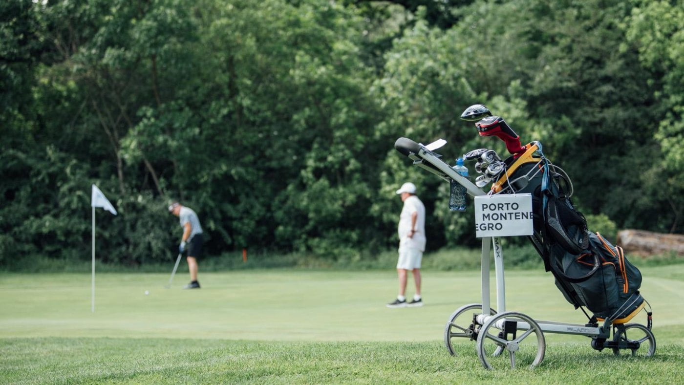 Golf field wit players and bag