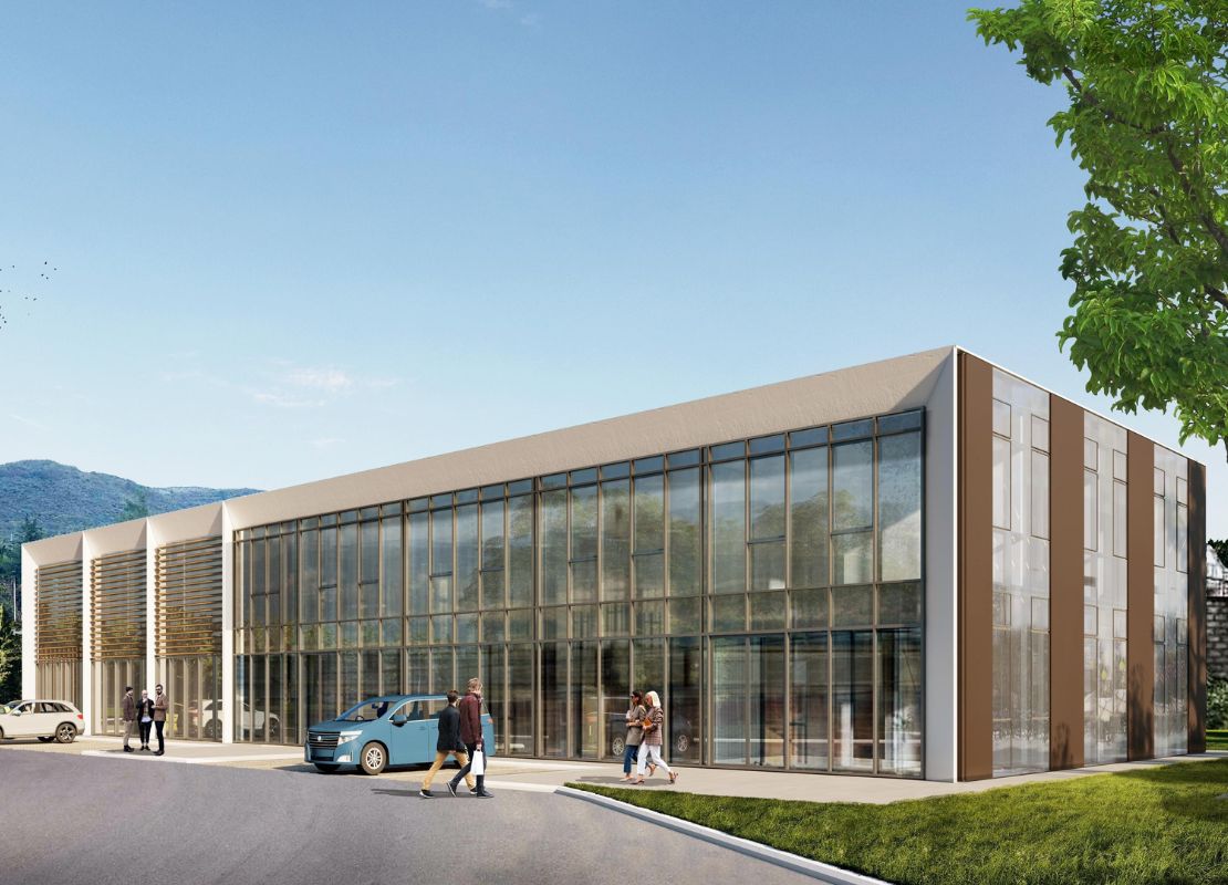 Entrance view of the Adriatic Business Club, showcasing the building in day light with its modern architectural design with a sleek glass facade, set amidst vibrant greenery, creating a serene and professional environment.