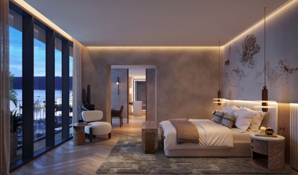 Elegant bedroom in AERIS, Porto Montenegro, with a contemporary design featuring a plush bed, artistic wall lighting, floor-to-ceiling windows providing views of the marina, and a cozy seating area, creating a warm and inviting atmosphere.