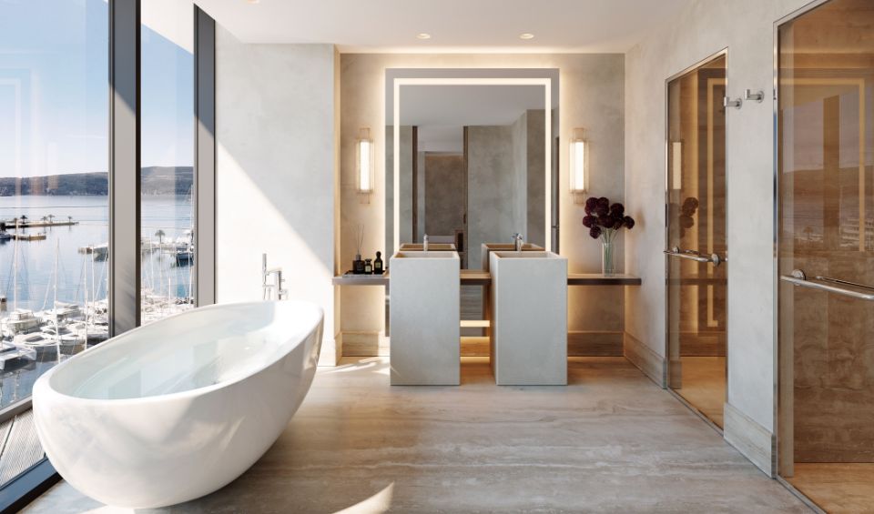 Luxurious bathroom in AERIS, Porto Montenegro, featuring a freestanding bathtub near floor-to-ceiling windows with a view of the marina, dual vanities, and a minimalist, elegant decor that enhances the serene ambiance.