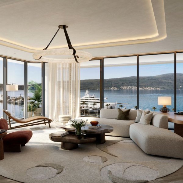 Luxurious living room in AERIS, Porto Montenegro, with contemporary furnishings, a sweeping view of the marina through floor-to-ceiling windows, creating a serene and stylish ambiance