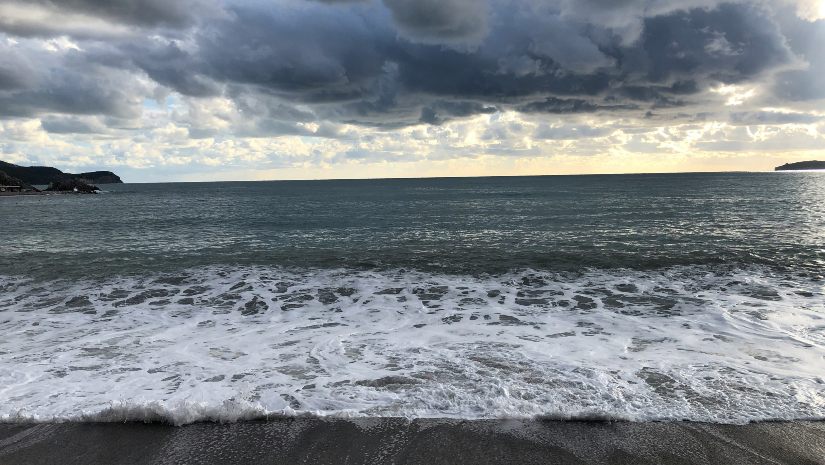 Waves of water under the grey sky.