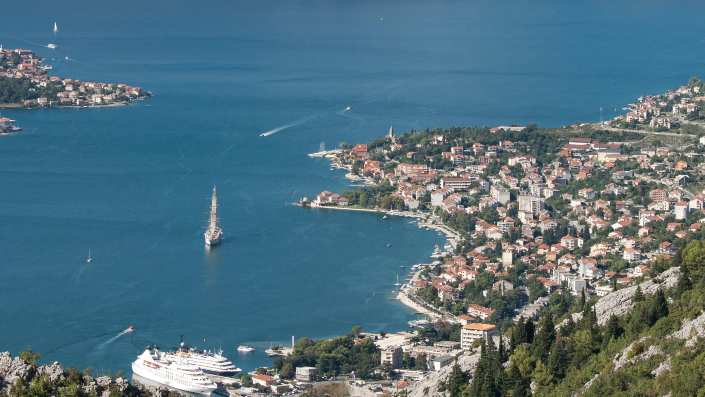 Scenic view of Boka Kotorska with the sea, ships, settlements, and sailboats, showcasing the breathtaking coastal landscape.