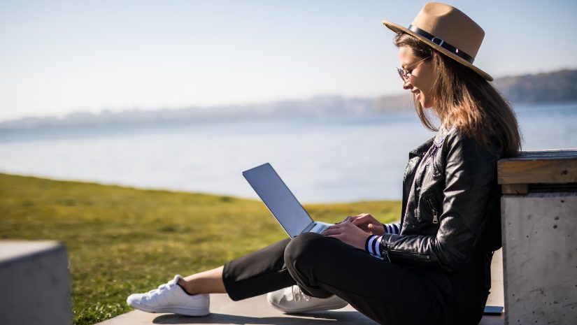 Women wearing a hat seating next to sea