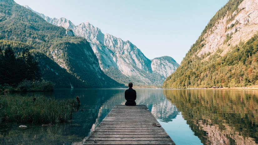 a man sitting on a wooden pontoon