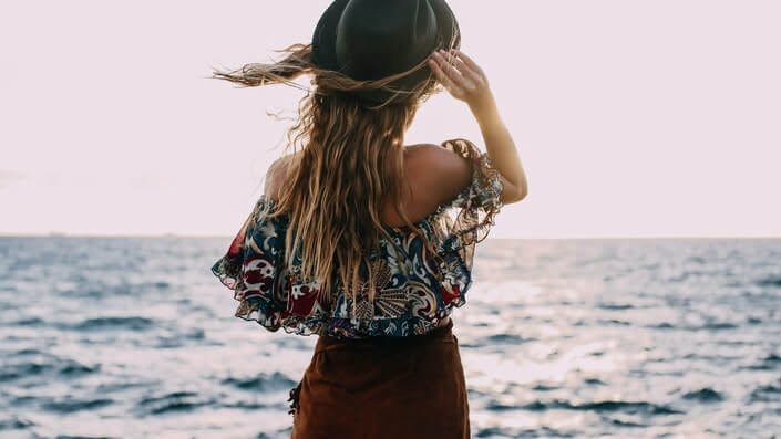 Girl with a hat on the beach