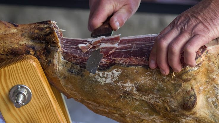 Man chopping a ham