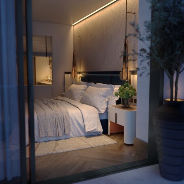 Cozy evening view of a bedroom in IVO Residences at Porto Montenegro, featuring a plush bed with white linens, elegant lighting, and a serene ambiance, viewed through a glass door.