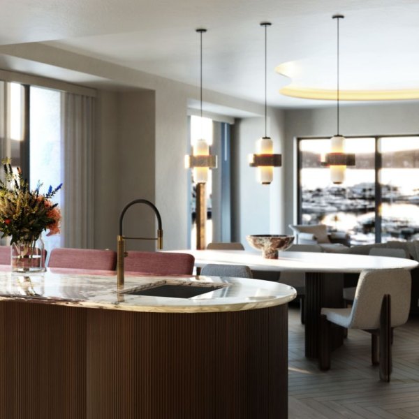 Sophisticated interior of a dining area in IVO Residences at Porto Montenegro, featuring a round marble bar counter, stylish pendant lights, and a scenic view of the marina through large windows.