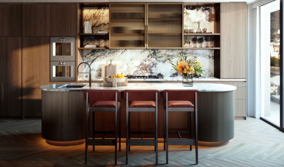 Luxurious kitchen interior in the IVO Residences at Porto Montenegro, featuring a curved marble island, wooden cabinetry, and modern appliances, with a panoramic window view.