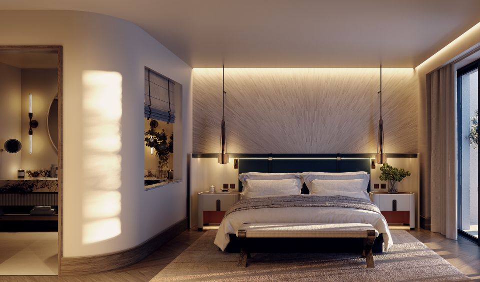 Modern and cozy bedroom interior at IVO Residences, Porto Montenegro, featuring a large bed with blue headboard, sophisticated lighting, and elegant wood finishes, with a partial view of the adjoining bathroom and a balcony overlooking the outdoors.