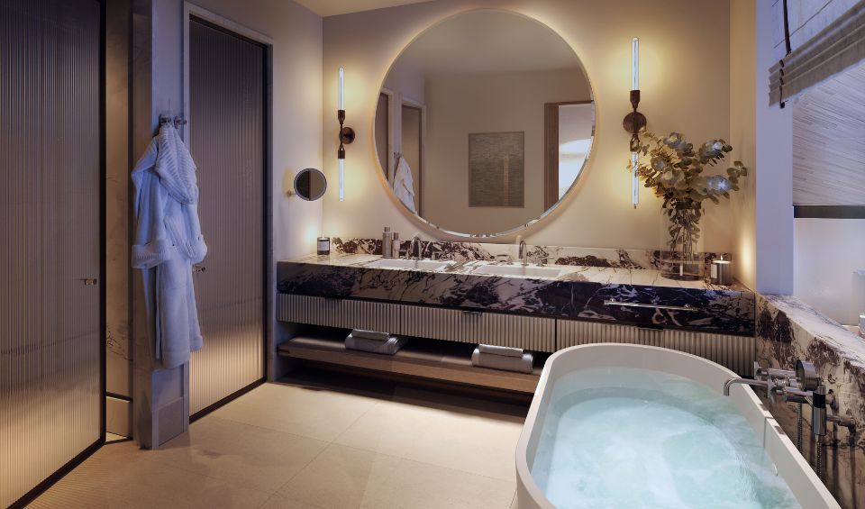 Luxurious bathroom interior in IVO Residences at Porto Montenegro, featuring a freestanding bathtub, large circular mirror, and elegant marble vanity, complemented by mood lighting and modern fixtures.Luxurious bathroom interior in Synchro Residences at Porto Montenegro, featuring a freestanding bathtub, large circular mirror, and elegant marble vanity, complemented by mood lighting and modern fixtures.