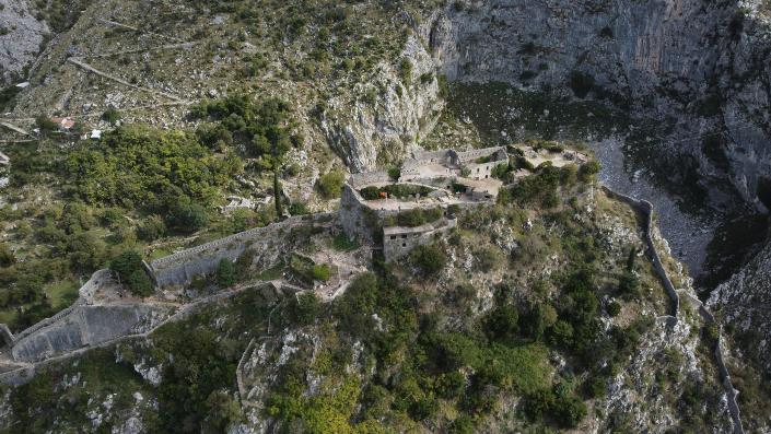 A stunning castle is situated on a cliff's edge, offering breathtaking views of the surrounding scenery below.
