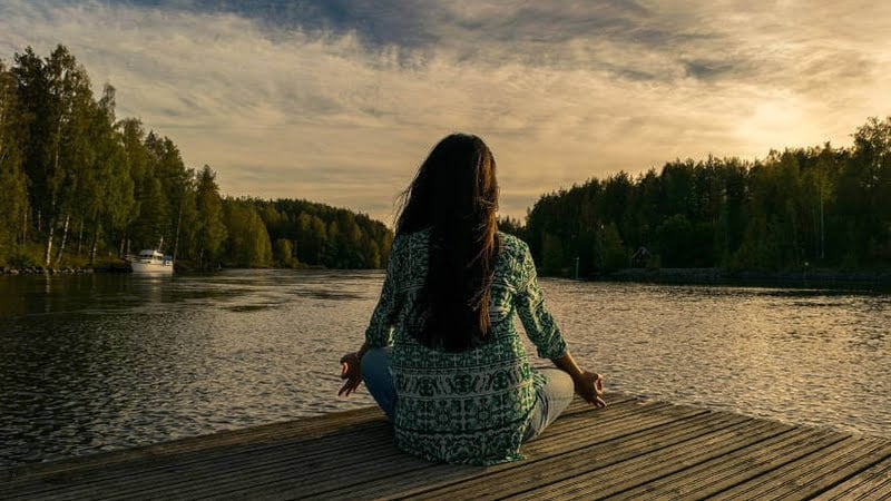 woman at the seaside meditating