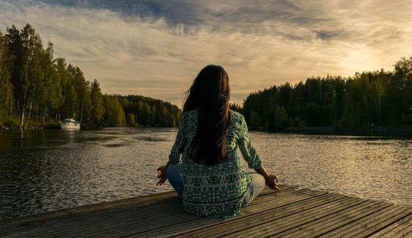 woman at the seaside meditating