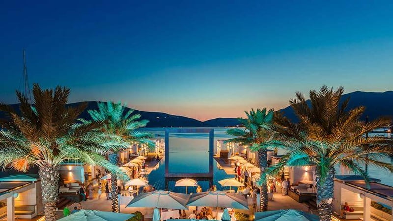 Scenic view of sea, palms and hills.