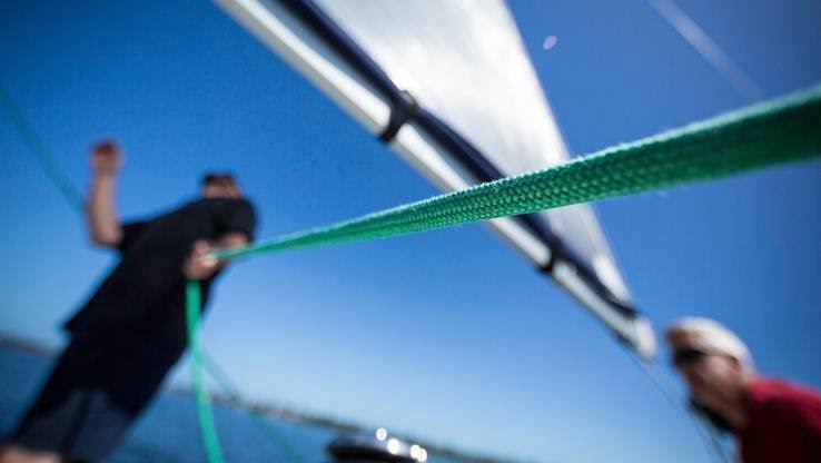 A man using a rope on the yacht.
