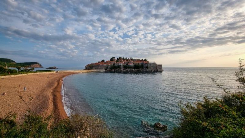 The picturesque coastline of Montenegro showcases a tranquil beach with soft sands and calm waters.