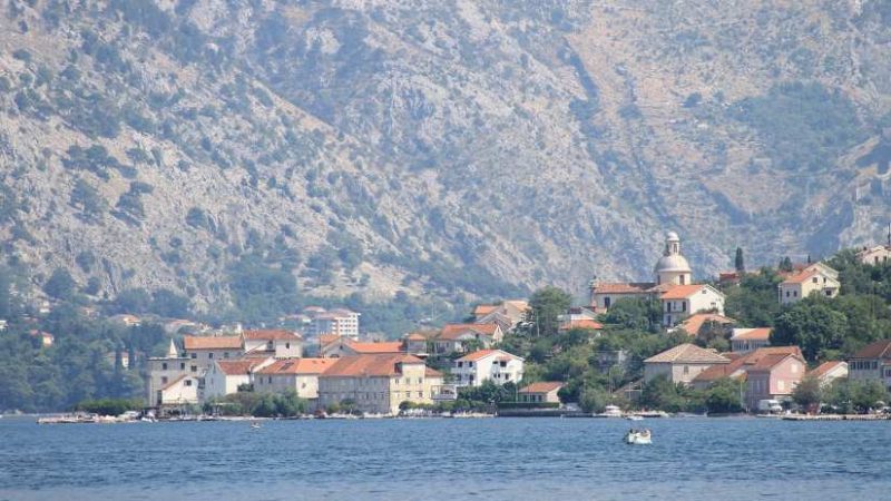 Stunning aerial view of Tivat, with the turquoise sea, green mountains, and the town’s harbor offering a glimpse of its natural beauty.
