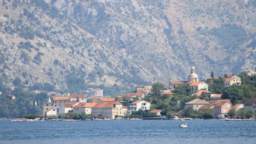Stunning aerial view of Tivat, with the turquoise sea, green mountains, and the town’s harbor offering a glimpse of its natural beauty.