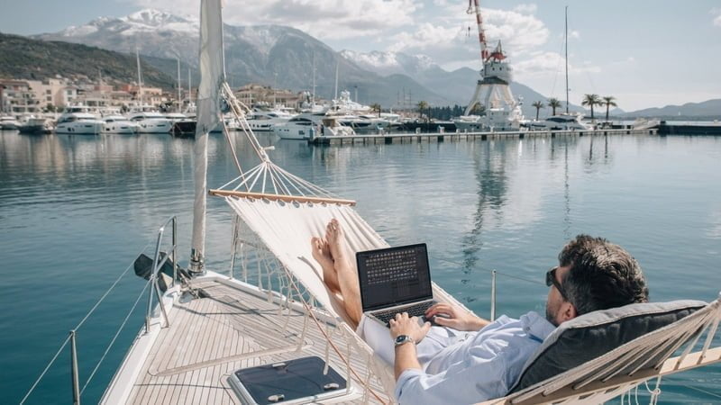 Man on laptop near the sea