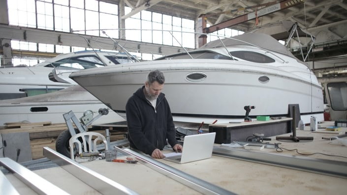 Man on computer side the yacht