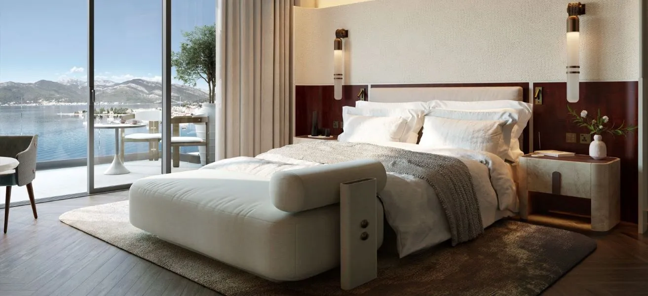 Luxurious bedroom with a marina view, featuring a plush bed, elegant furnishings, and floor-to-ceiling windows that open to a serene waterfront scene.