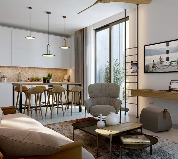 Stylish open-plan living and kitchen area at Boka Place residences, with modern furnishings. A dining space with bar stools complements the cozy living room, which includes a sofa, armchair, and wall-mounted TV.