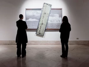 Two people viewing a Darja Bajagic art installation in a gallery.