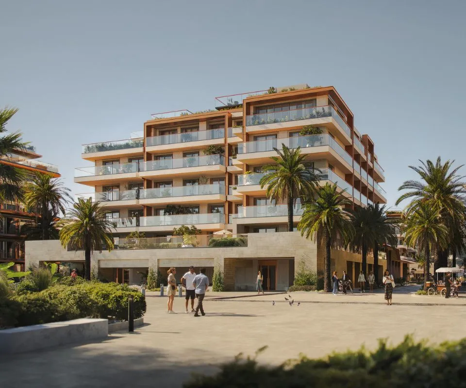 Modern IVO Residences building in Porto Montenegro, featuring spacious balconies, palm trees, and people walking in a sunny plaza.