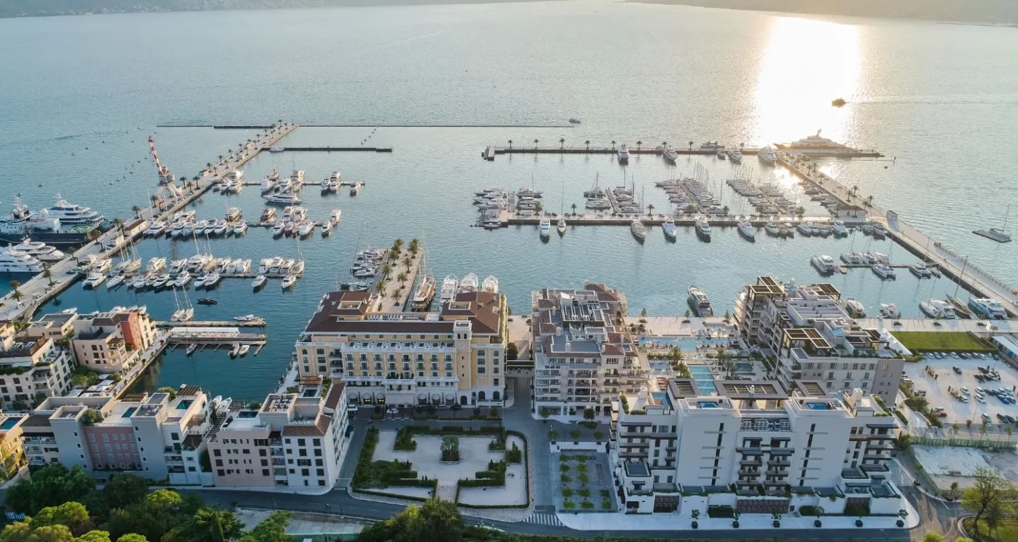 View from above of Porto Montenegro's South Village waterfront, highlighting the marina, piers, and nearby residential and commercial structures.