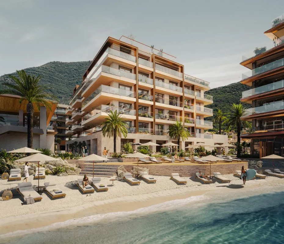 IVO Residences on a sunny day, featuring beachfront apartments with balconies, palm trees, and loungers.